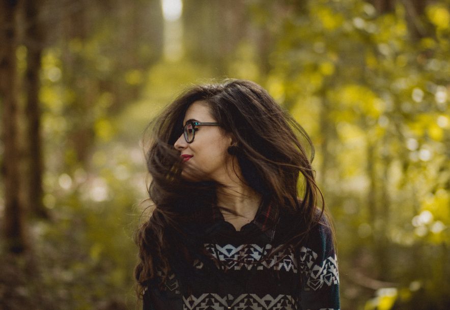 A woman swaying her hair in a forest near Barnstaple