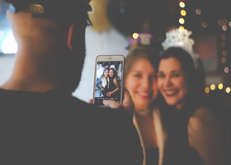 Two girls having their picture taken on New Year’s Eve